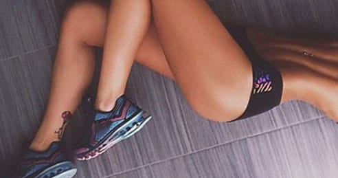 Mulher fitness linda com bumbum sarado deitada de lado no chão pensando sobre sexo anal